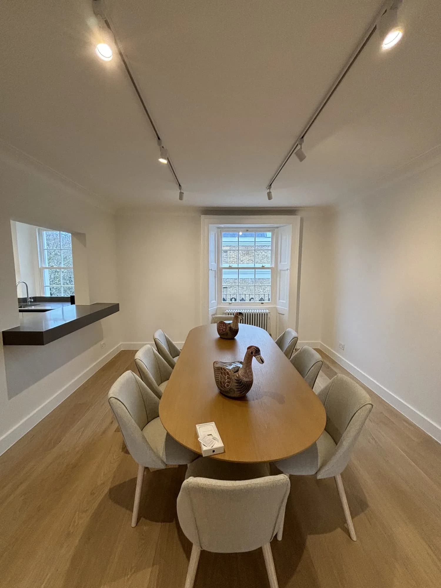 Belgravia: dining room with an oval oak table, upholstered chairs and track lighting