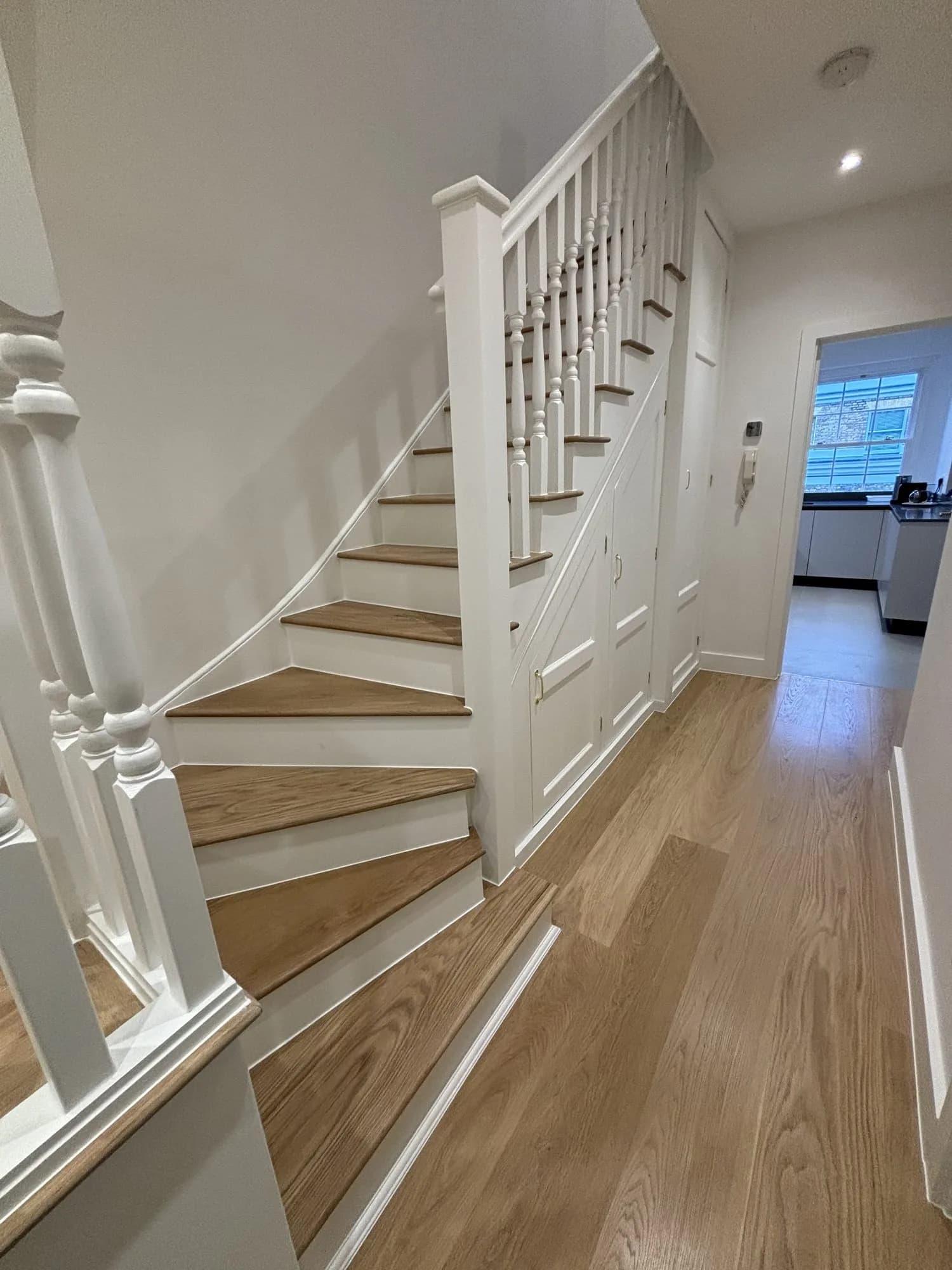 Belgravia: white-painted staircase with oak treads and a turned spindle balustrade