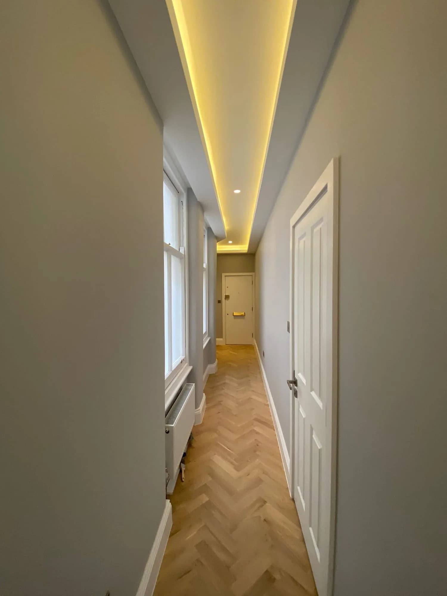 Chelsea I: hallway with herringbone parquet and concealed cove lighting