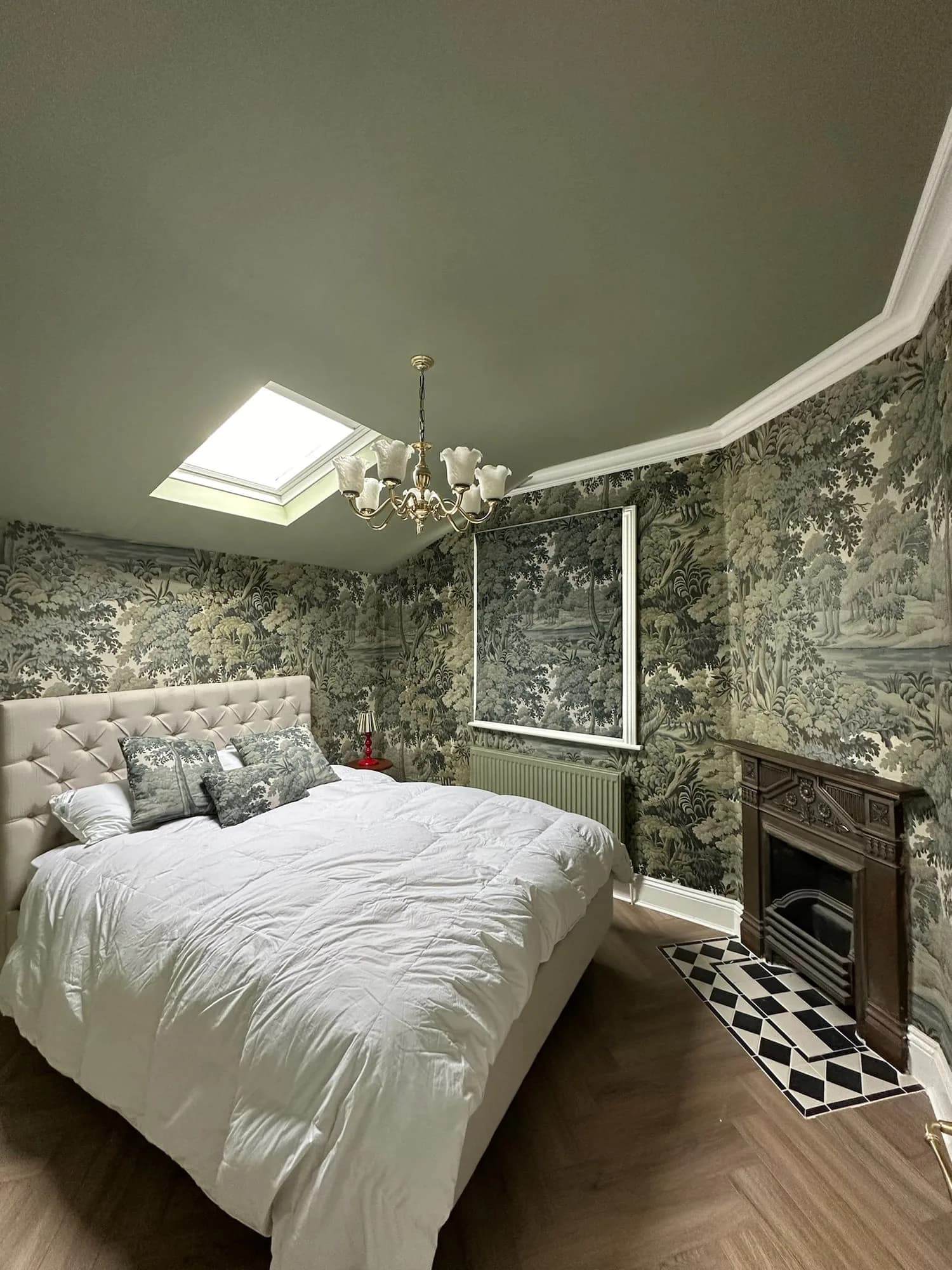 Earls Court III: bedroom with toile wallpaper, a rooflight and a cast-iron fireplace