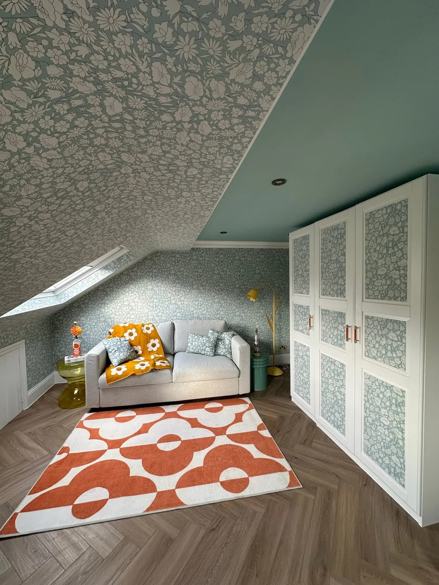 Earls Court III: attic sitting room with patterned wallpaper and fitted cupboards
