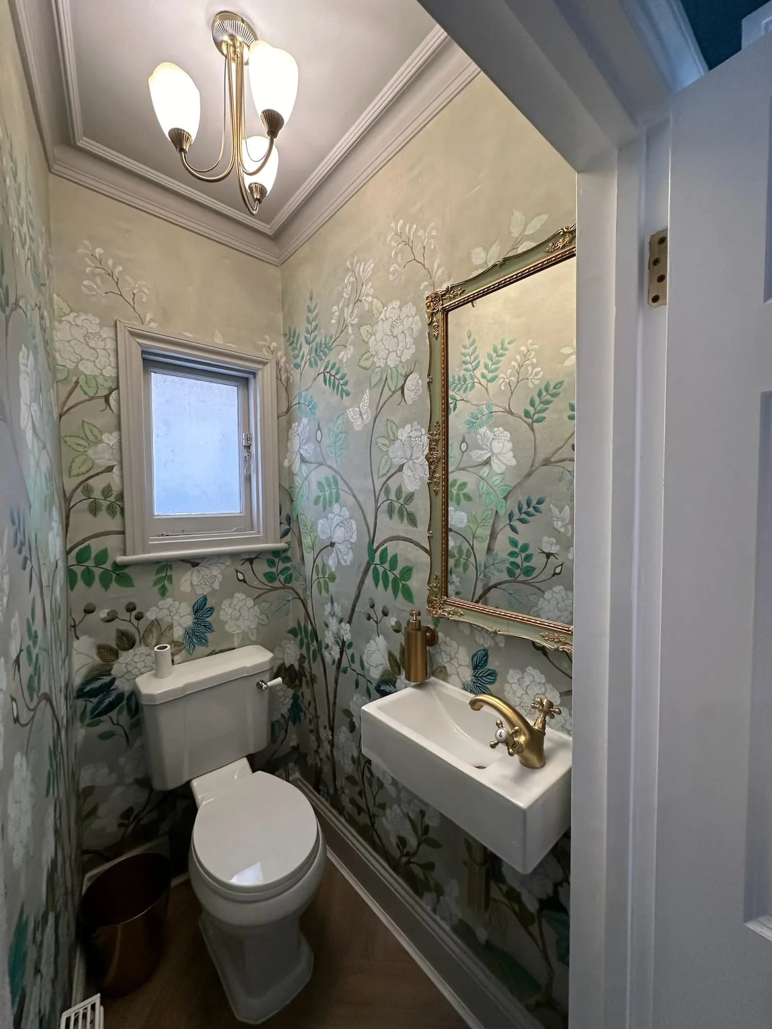 Earls Court III: cloakroom papered in a hand-painted garden mural, with a brass tap