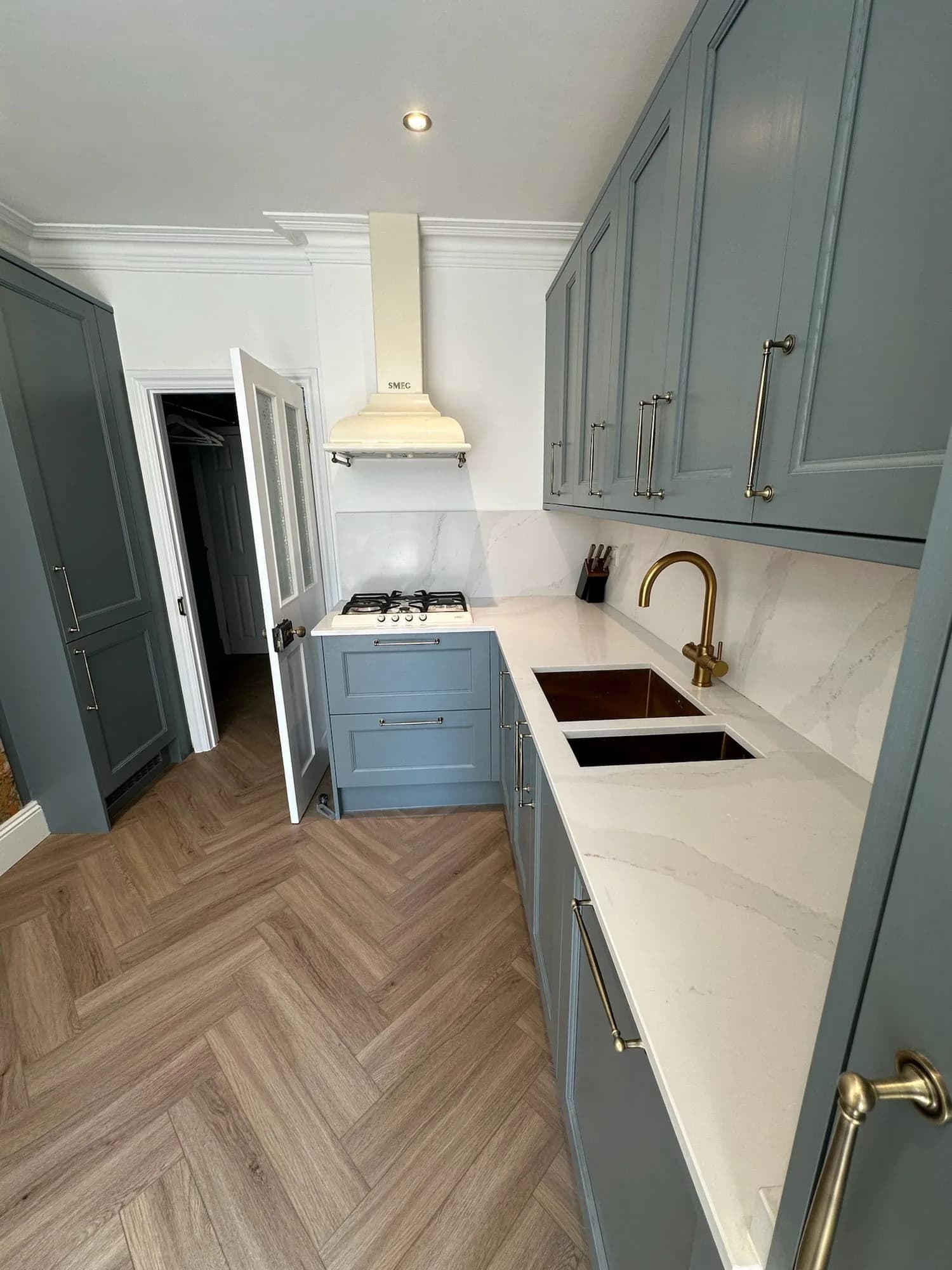 Earls Court II: pale blue kitchen with a marble worktop and a herringbone floor