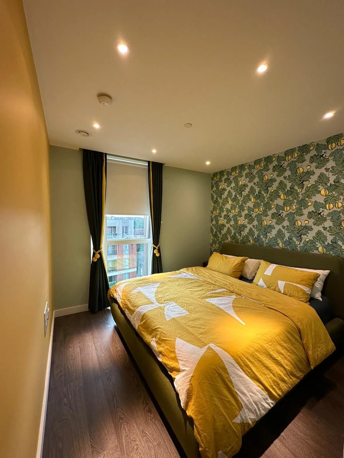 Finsbury Park: bedroom with patterned wallpaper, ochre bedding and a wide window