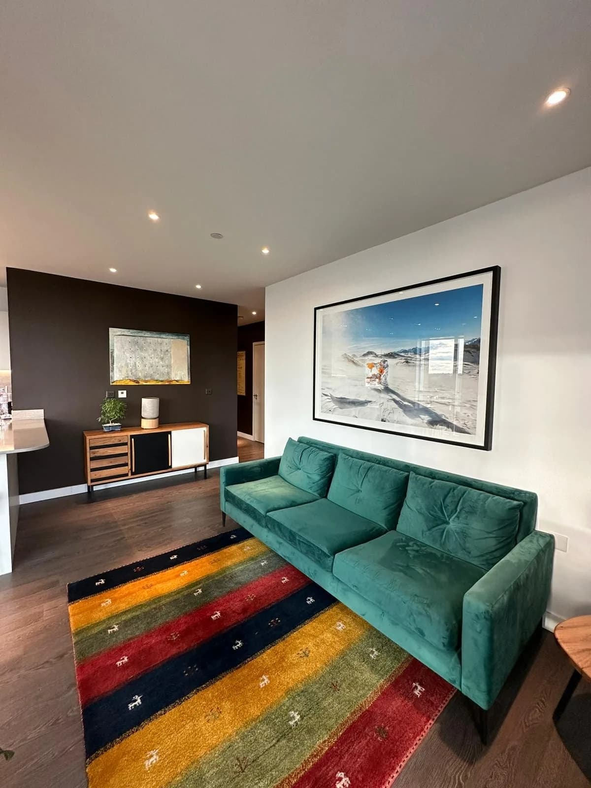 Finsbury Park: living room with a green velvet sofa on a striped wool rug
