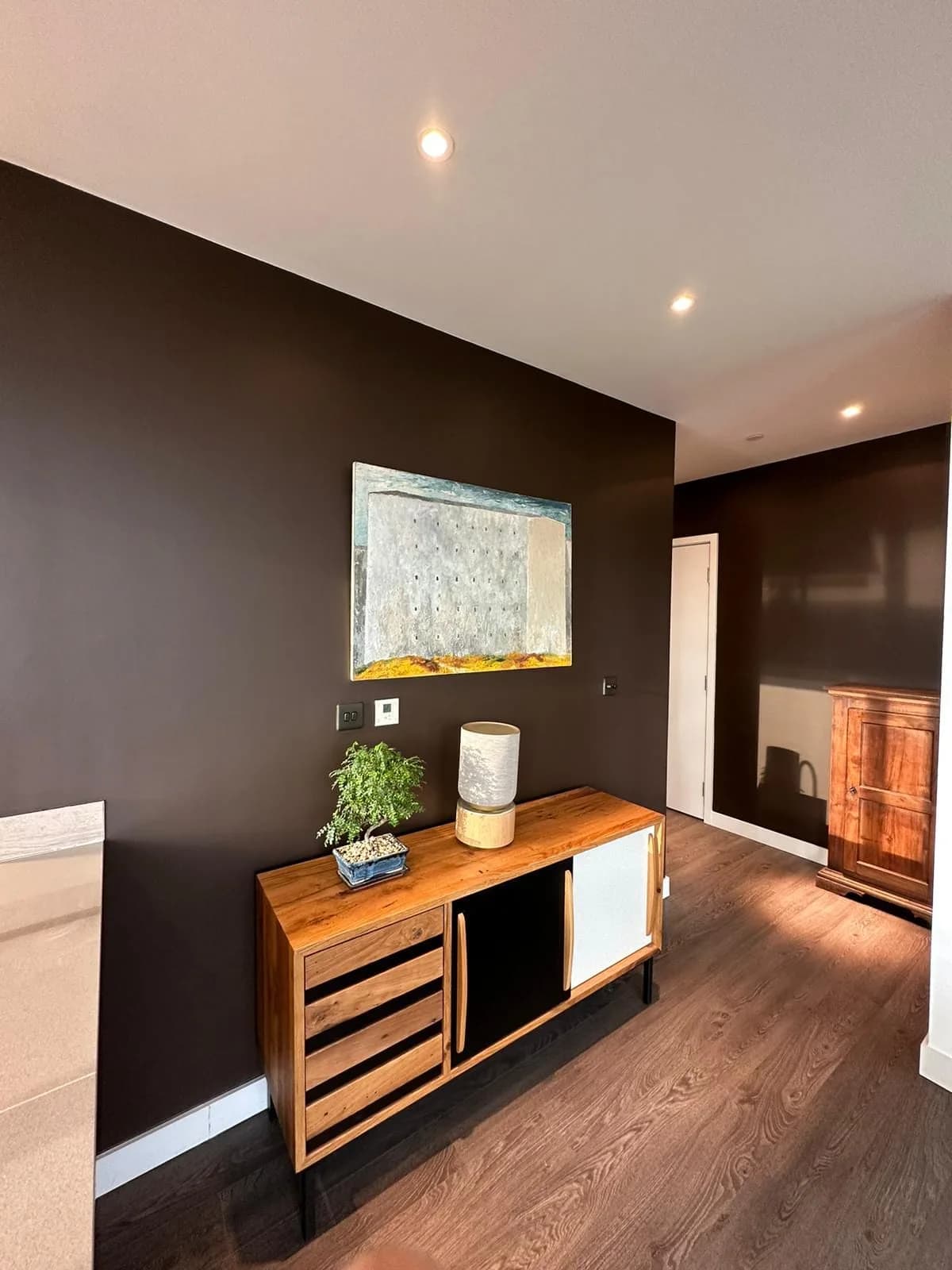 Finsbury Park: walnut sideboard against a dark feature wall in the living room