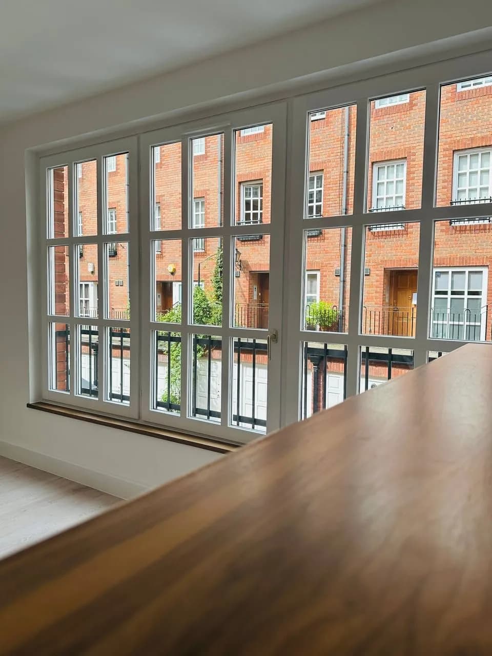 High Street Kensington: walnut breakfast bar beside a window over a red-brick mews