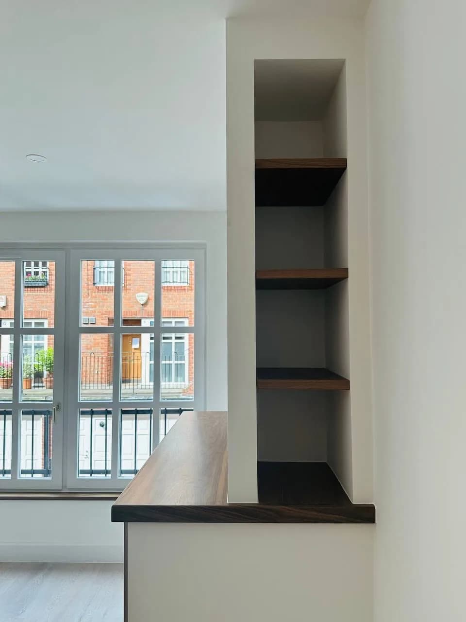 High Street Kensington: built-in walnut shelving beside the kitchen counter