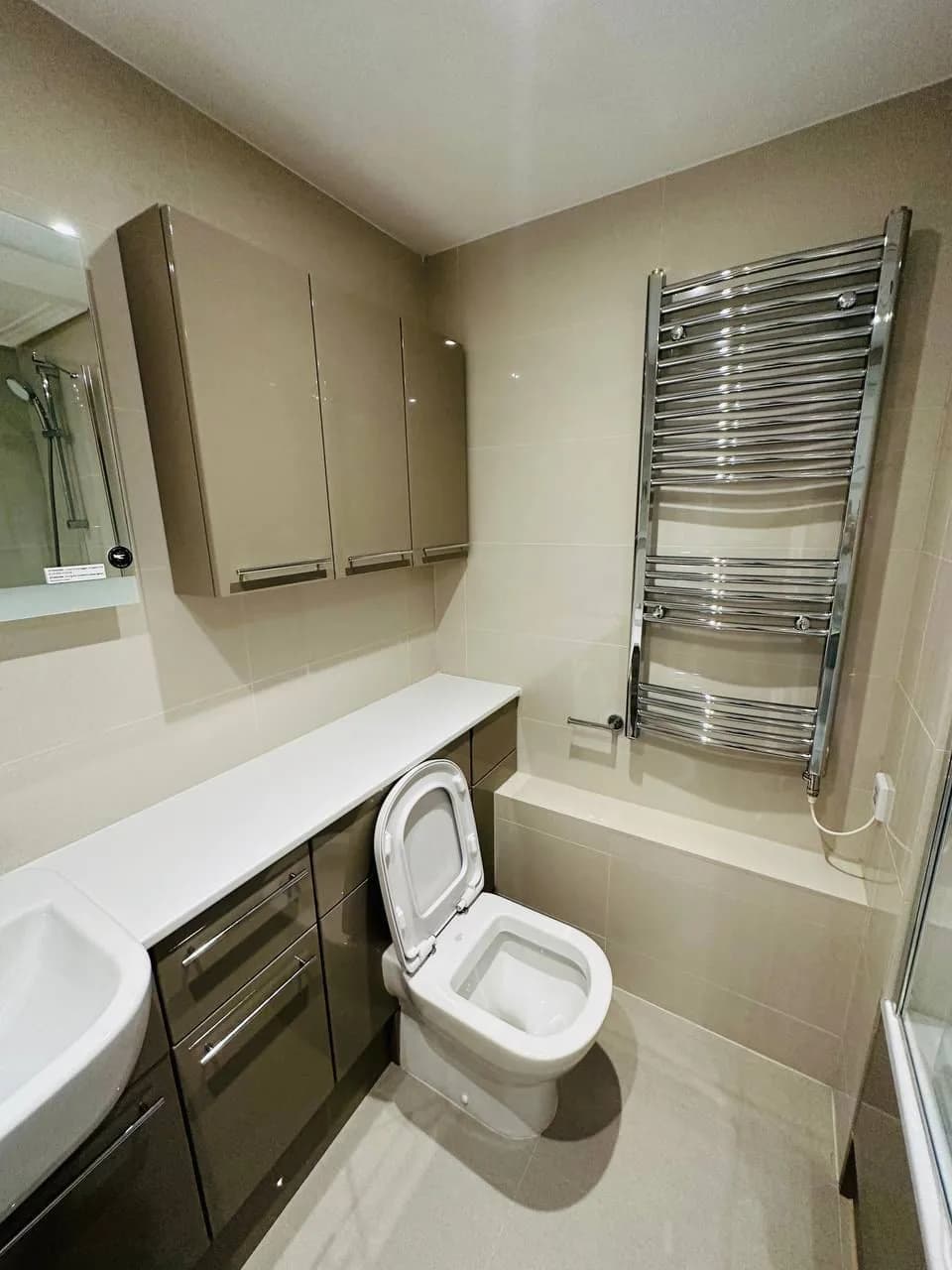 High Street Kensington: bathroom with a fitted vanity, mirrored cabinet and towel radiator
