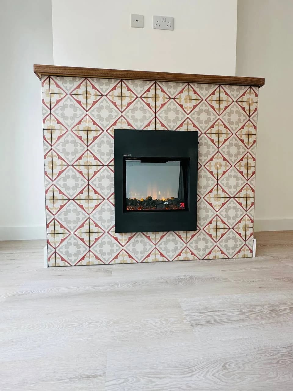High Street Kensington: fireplace surround in patterned encaustic tiles with a walnut mantel