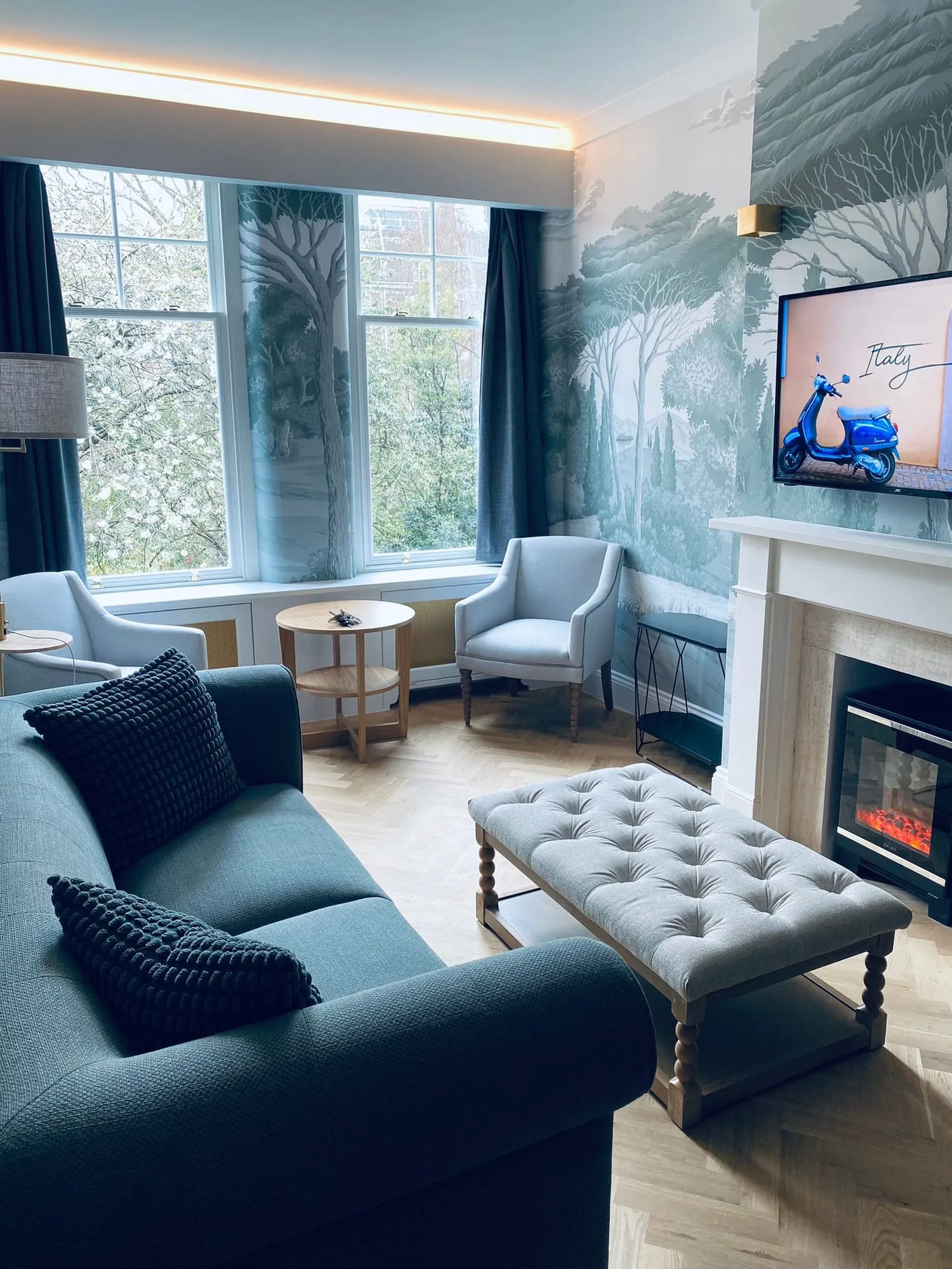 Chelsea I: sitting room with a teal sofa, a buttoned ottoman and a marble fireplace
