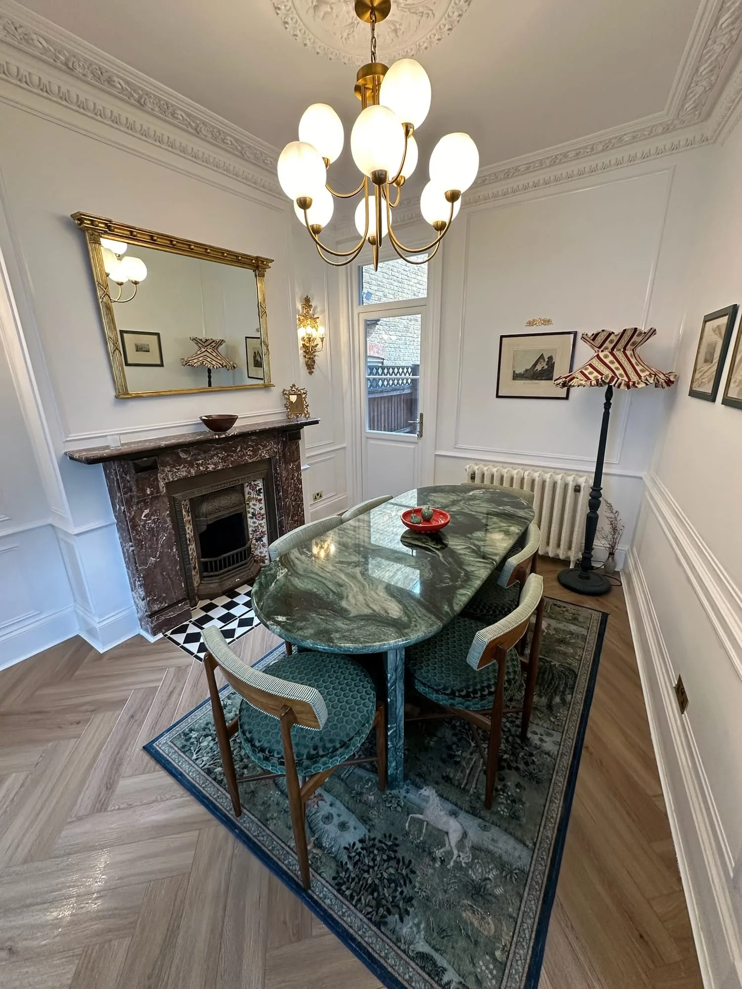 Earls Court III: dining room with a marble fireplace, chandelier and panelled walls