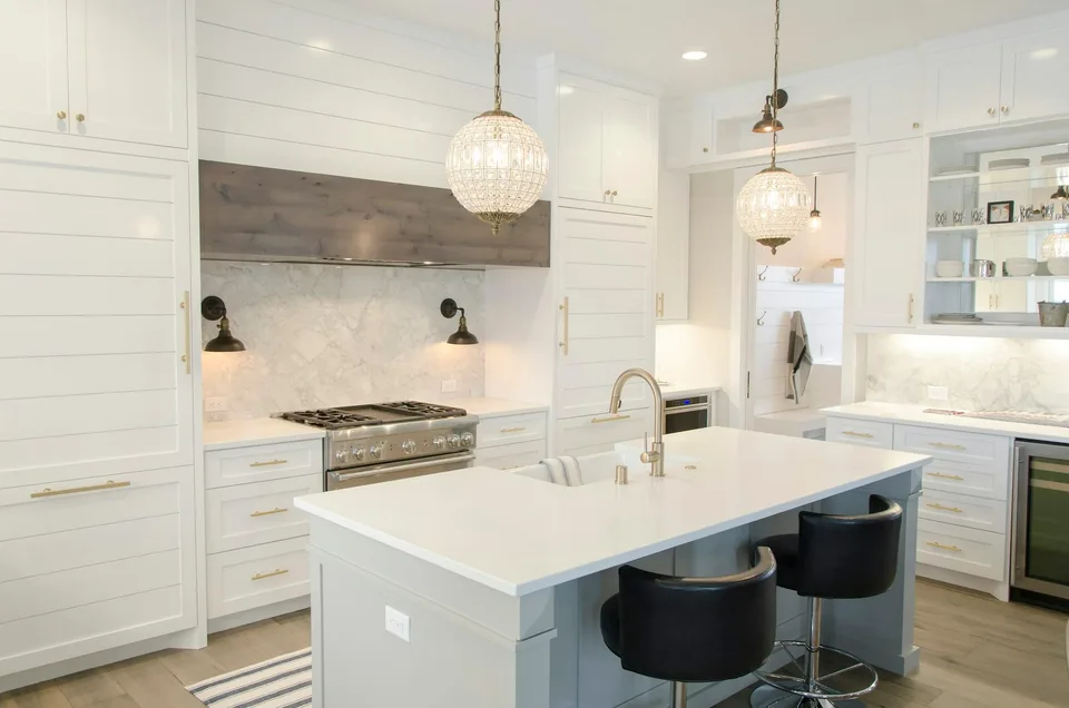 Bespoke white kitchen with a marble splashback, crystal globe pendants and a large island