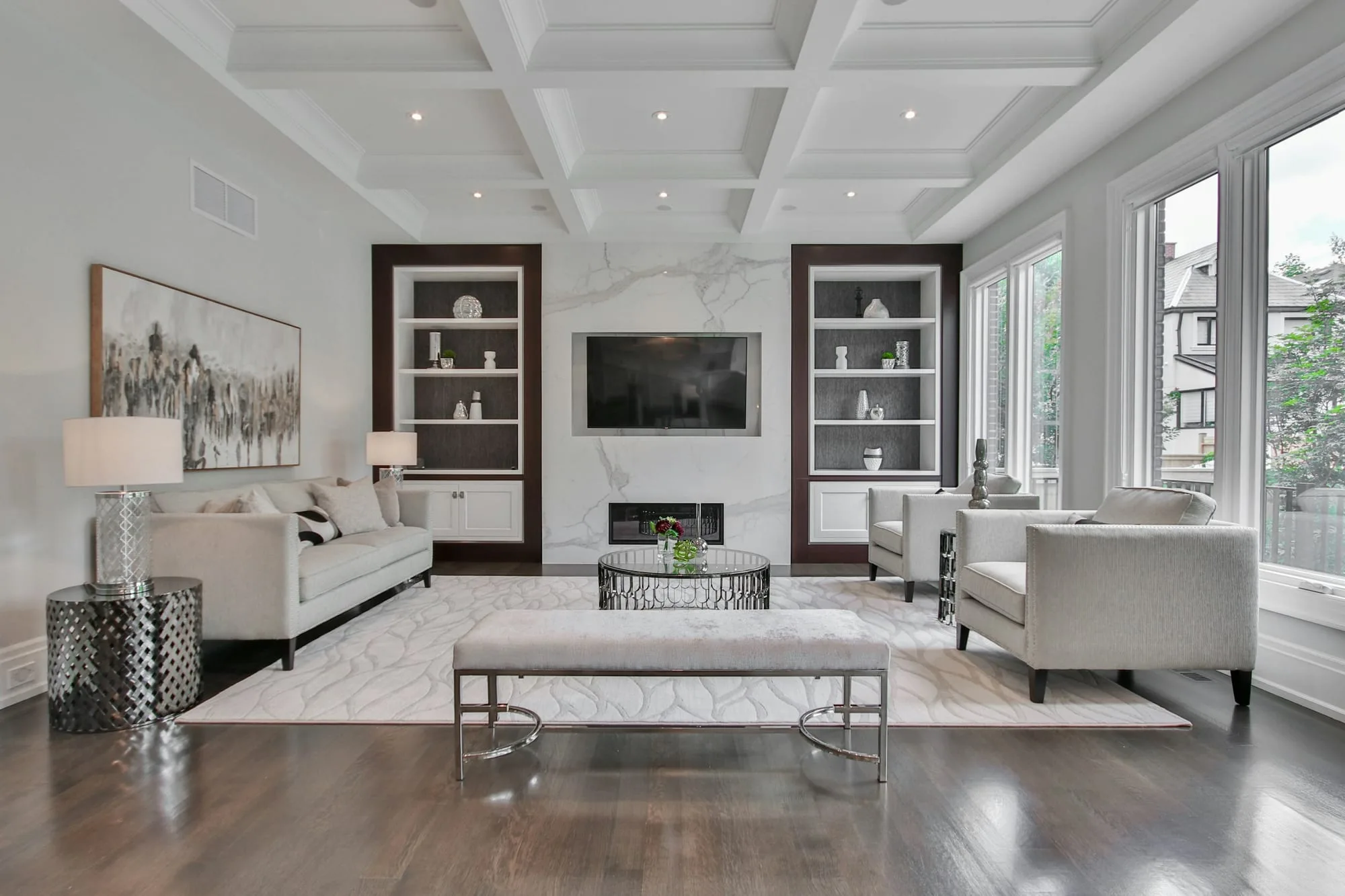 Formal living room with a coffered ceiling, glazed display cabinets and a marble chimney breast