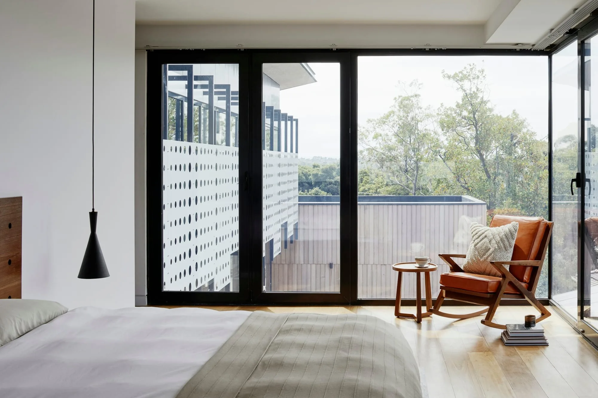 Quiet bedroom with sliding doors opening onto a planted terrace