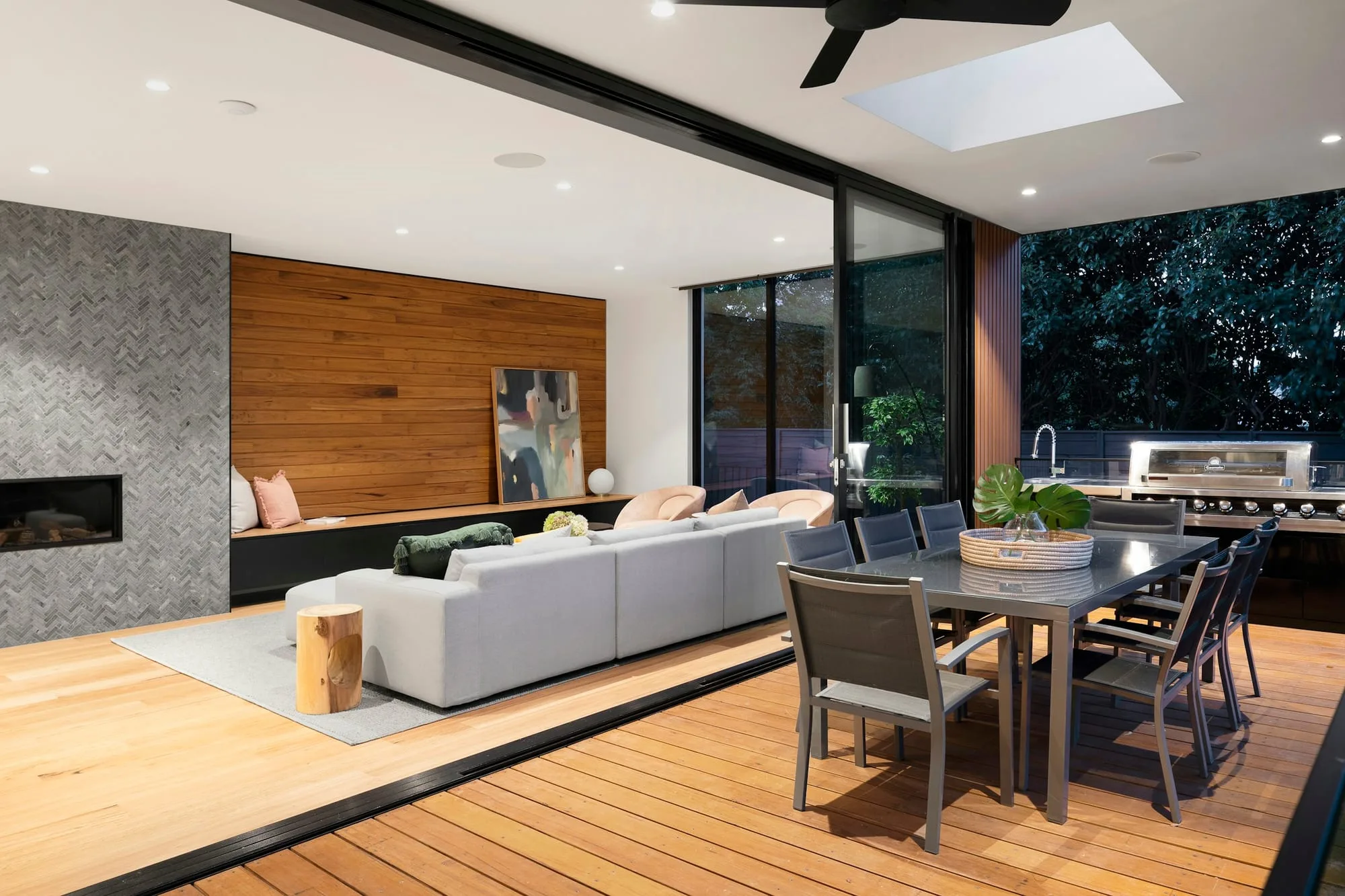 Calm open-plan living and dining room opening onto a timber deck